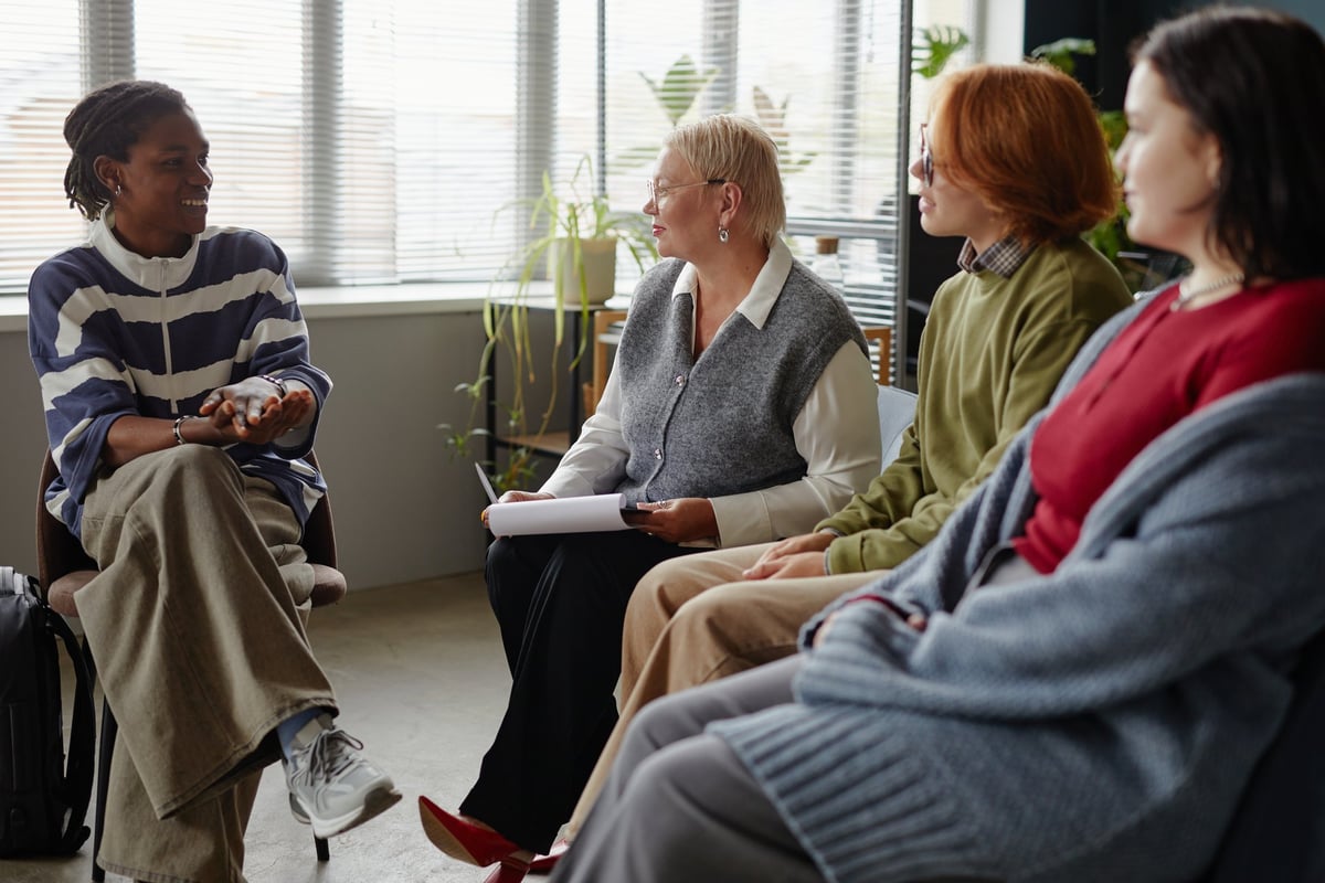 A group sitting in a circle in discussion during a community meeting