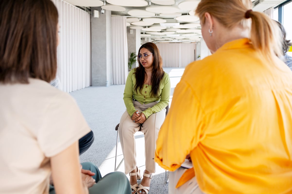 A woman speaking openly in a circle during a support group meeting